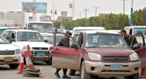 A polícia verifica viaturas num posto de controlo na estrada para o aeroporto internacional da capital iemenita, Sana