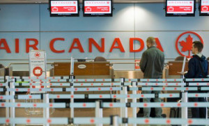 Fila de passageiros num guichet de check-in da Air Canada, no aeroporto Trudeau, em Montreal. THE CANADIAN PRESS/Graham Hughes