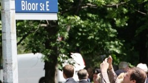 Um homem tira uma foto de um novo sinal de rua "Route of Heroes" em Toronto. Imagem de arquivo: (The Canadian Press / Colin Perkel)