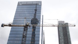 A torre CN é refletida num edifício alto atrás de uma grua de construção no centro de Toronto, nesta foto de arquivo. (The Canadian Press / Pawel Dwulit)