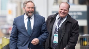 O líder do NDP Tom Mulcair e o Diretor Nacional do Partido Nova Democracia Karl Belanger compartilham uma risada enquanto caminham para a cimeira Progresso em Otava - 1 de abril de 2016. The Canadian Press/Adrian Wyld