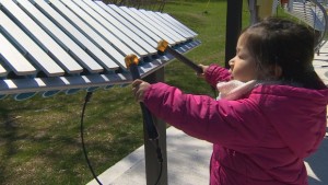 Uma criança toca um dos vários instrumentos instalados no Jeff Healey Park em Etobicoke. Alguns vizinhos estão descontentes com o ruído do parque infantil. (CBC)