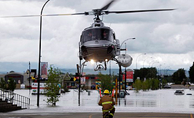 Um helicóptero que transportava moradores evacuados aterra numa estrada em High River, Alta., - 20 de junho, 2013. (THE Canadian Press / Jeff McIntosh)