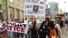 Manifestantes marcham ao longo da Dundas Street (Brian Carr/CP24.com)