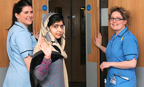 Malala Yousafzai diz adeus depois de ter alta de um hospital britânico para continuar a sua reabilitação, na casa temporária da sua família na Inglaterra. (THE ASSOCIATED PRESS / Queen Elizabeth Hospital Birmingham)