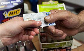 Um consumidor paga com cartão de crédito, numa loja em Montreal. THE CANADIAN PRESS/Ryan Remiorz