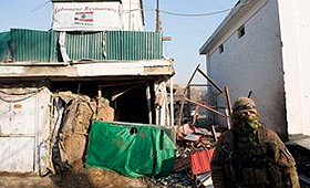 Entrada do restaurante vigiada por um militar, após o ataque. (Getty Images)