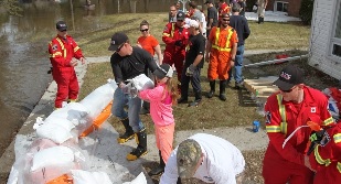 Voluntários adicionam sacos de areia para as casas na área de Foxboro, Ontário, afetadas pelo rápida subida das águas do rio Moira - 12 de abril de 2014. (Lars Hagberg / The Canadian Press)