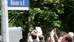 Um homem tira uma foto de um novo sinal de rua 