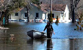 Shelley Sager puxa um barco onde transporta sacos de areia com vista a ajudar a manter protegida a casa da sua mãe das cheias em Foxboro, a norte de Belleville, Ontário. - 17 abril de 2014. (The Canadian Press/Sean Kilpatrick)