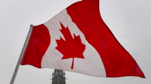 Bandeira canadiana esvoaça perto da torre da paz, no Parliament Hill em Ottawa. Foto de arquivo. (The Canadian Press / Adrian Wyld)