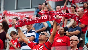 Adeptos do Toronto FC mostram o seu apoio, no momento em que o hino nacional é entoado, antes da equipa defrontar os Columbus Crew, num jogo da MLS em Toronto. Foto de arquivo. (The Canadian Press / Michelle Siu)