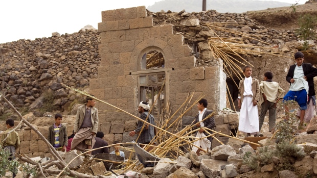 Iemenitas juntam-se, em busca de sobreviventes nos escombros de casas destruídas por ataques aéreos sauditas numa vila perto de Sanaa, no Iémen - 4 de abril de 2015. (Hani Mohammed / AP Photo)