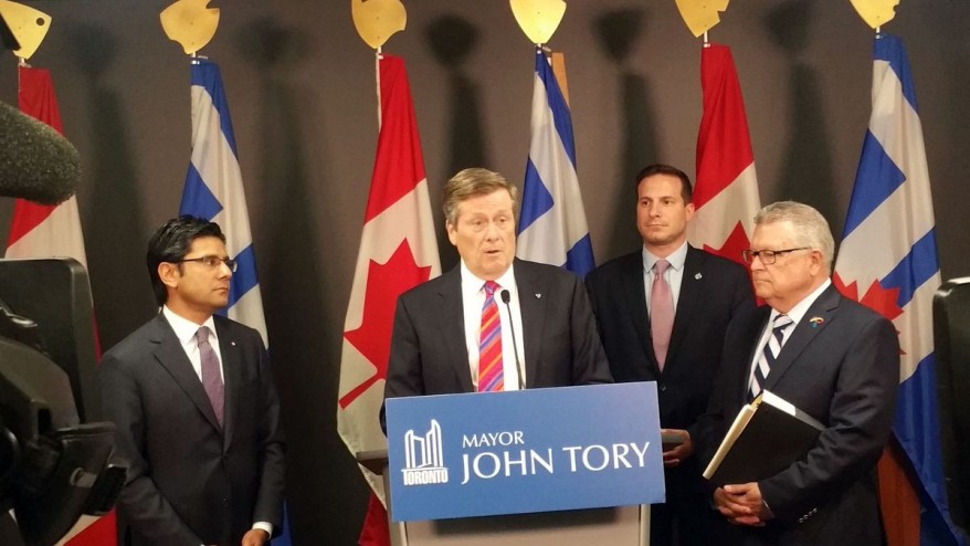 O presidente John Tory anuncia novas iniciativas de segurança ao lado dos ministros Yasir Naqvi e Ralph Goodale e o deputado federal Marco Mendicino na Câmara Municipal - 30 de junho de 2016. TWITTER / Momin Qureshi